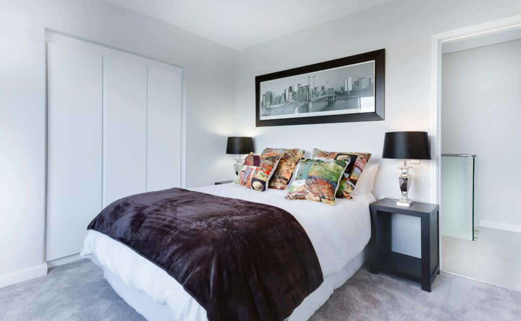 Tidy bedroom with soft lighting, a made bed, and organized shelves – showing a clean, peaceful space
